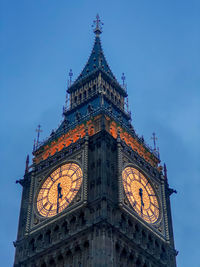 Low angle view of clock tower against clear blue sky