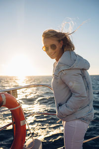 Portrait of woman standing in boat on sea against sky