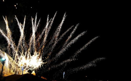 Low angle view of firework display at night