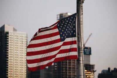 Close-up of american flag against buildings in city