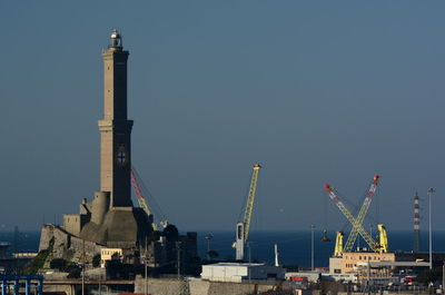 Factory by buildings against clear sky
