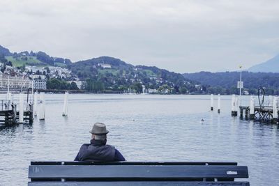 Man sitting on bench by lake
