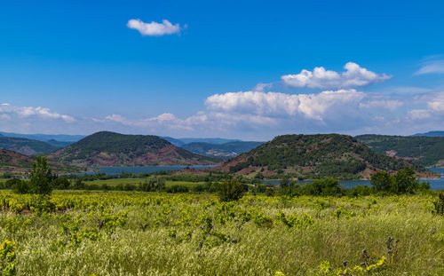 Scenic view of landscape and mountains against blue sky