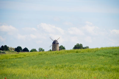 Traditional windmill on field against sky