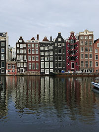 Reflection of buildings in river against sky