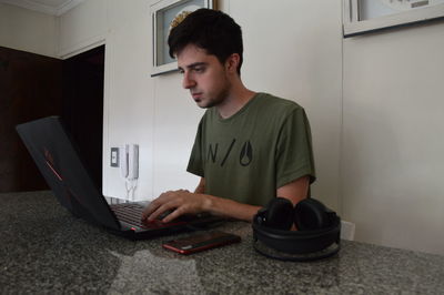 Young man using mobile phone at home
