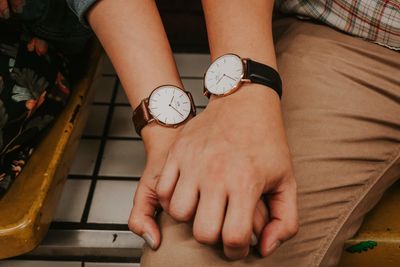 Midsection of woman holding hands at home