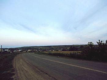 Road by landscape against sky