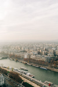 High angle view of river by buildings in city against sky