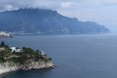 Scenic view of sea and mountains against sky