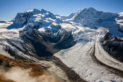 Aerial view of snowcapped mountains against clear sky