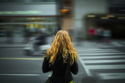 Rear view of woman standing in bus