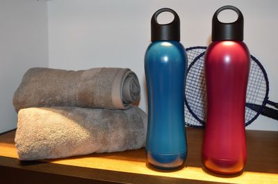 Close-up of bottles by towels on table