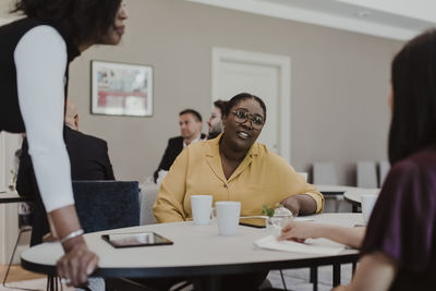 Businesswoman discussing with female employees in education class