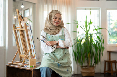 Portrait of young woman sitting on table