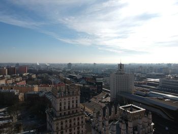 High angle view of city buildings against cloudy sky