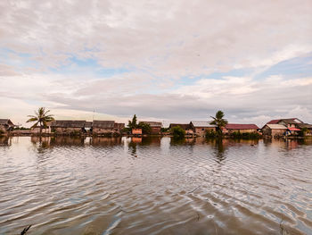 Scenic view of lake by building against sky