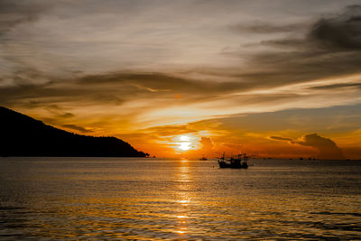 Scenic view of sea against dramatic sky during sunset