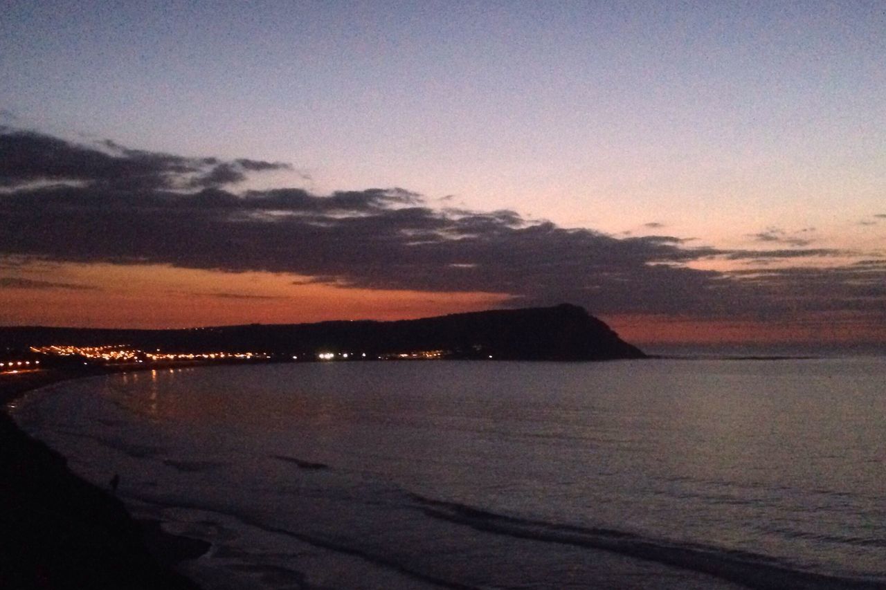 sea, water, scenics, tranquil scene, tranquility, beach, sky, beauty in nature, sunset, shore, nature, idyllic, dusk, coastline, mountain, horizon over water, cloud - sky, silhouette, outdoors, calm