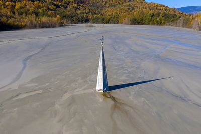 Aerial view of church tower with cross, buried under mining residuals.  transylvania, romania