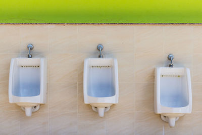 Closeup of three white ceramic urinals in men's bathroom.urinal designed for the children.