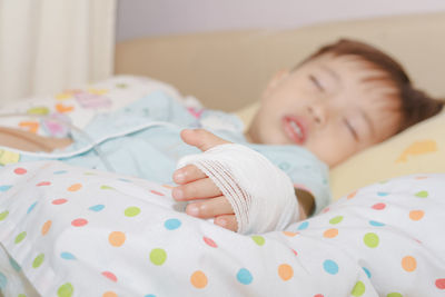 Boy sleeping with bandage on bed