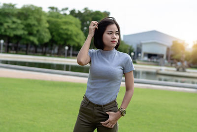 Portrait of young woman standing on field