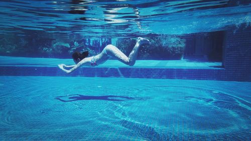 Side view of girl swimming in pool