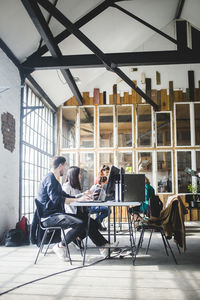 Team of computer programmers working at conference table in board room