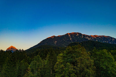 Scenic view of mountains against clear blue sky