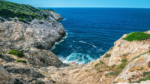 Rock formations by sea against sky