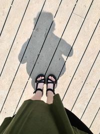 Low section of woman standing on boardwalk