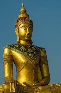 Low angle view of statue against temple building against sky