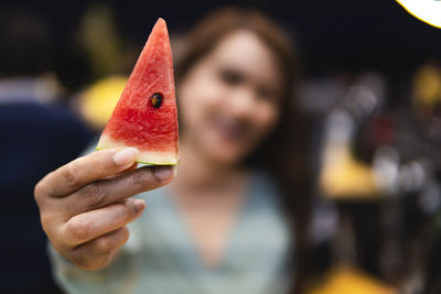 Close-up of woman holding watermelon outdoors