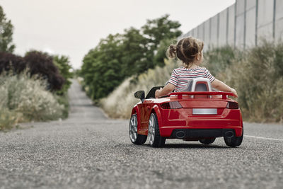 A girl riding a toy car