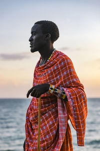 Full length of young man looking at sea against sky