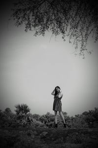 Woman standing on field against sky
