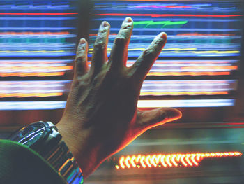 Close-up of hand touching illuminated light