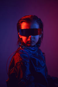 Portrait cyberpunk boy child in vr glasses in blue and red tones. game, virtual reality