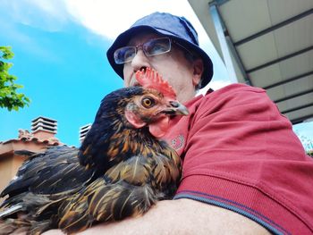 Low angle portrait of young man by bird