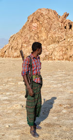 Rear view of man standing on rock