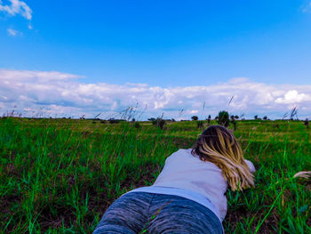 Low section of woman on field against sky