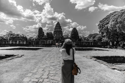 Rear view of woman photographing against sky