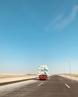 Cars on road against blue sky