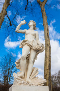 Low angle view of angel statue against blue sky