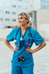 Portrait of young woman standing in city