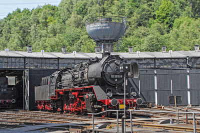 Train on railroad tracks against trees