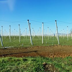 Fence on grassy field against cloudy sky