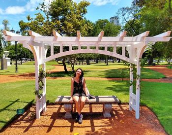 Full length of young woman on seat at park