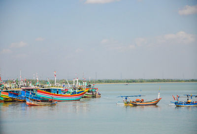 Boats moored in sea against sky